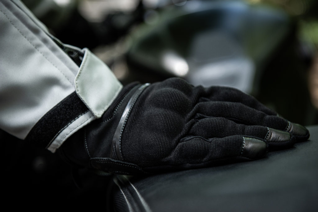 Gants moto be Fresh 2 portés, la mains posé sur une selle